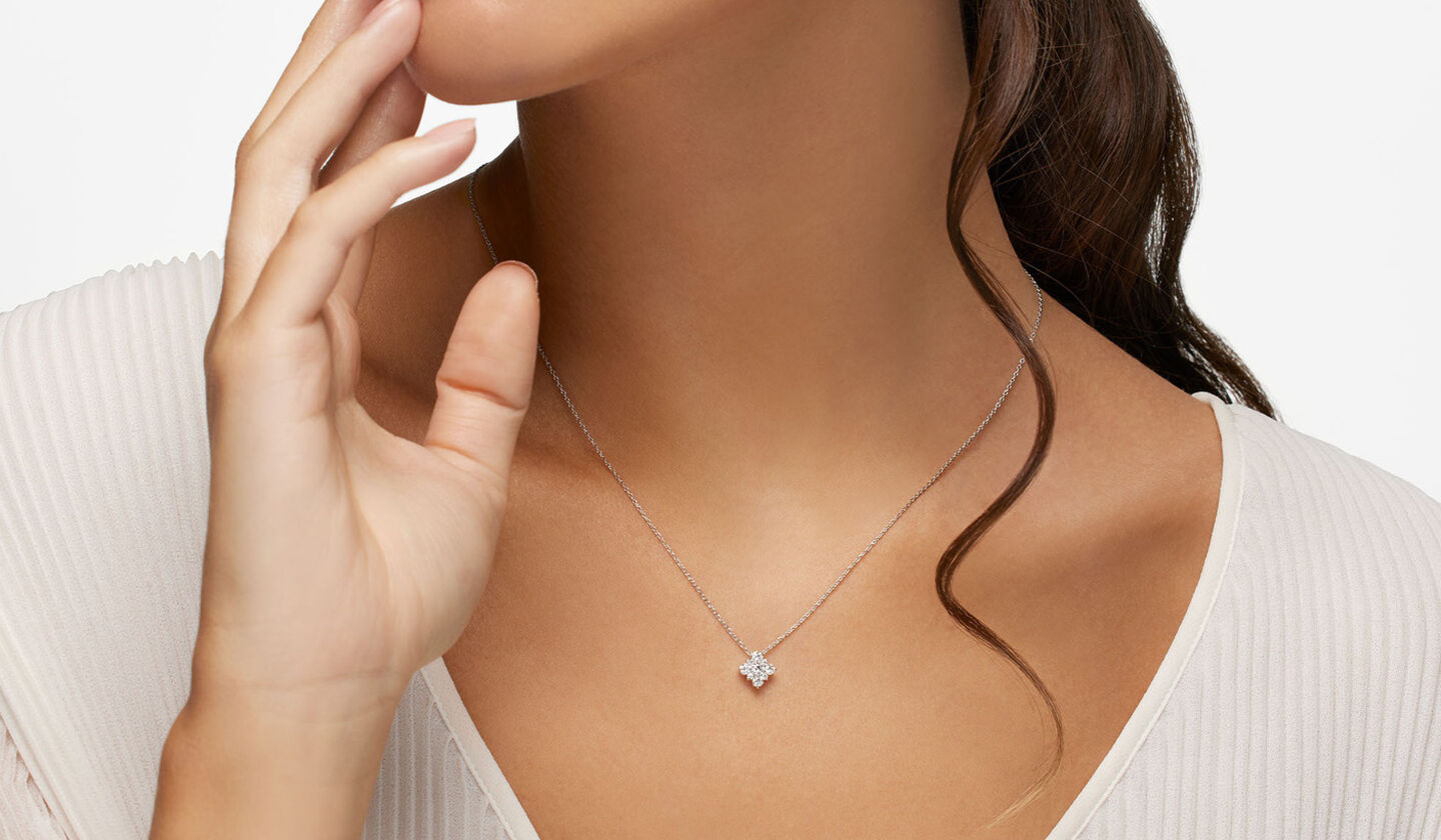 A woman wearing a Birks Snowflake cluster diamond pendant.